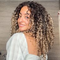 Curly lit brunette: tips for those who want to leave dark strands with lighter highlights